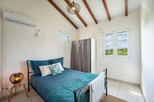 a bedroom with a bed and a window at Séjour nature dans un écrin de modernité in Les Abymes