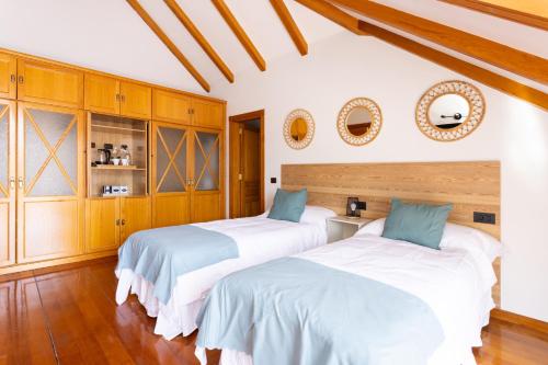 two beds in a room with wooden cabinets at Casa Lali Habitación 3 in La Laguna