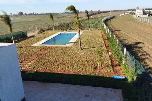 a garden with a swimming pool in a field at Maison+piscine dans une ferme benslimane in O Ben Slimane