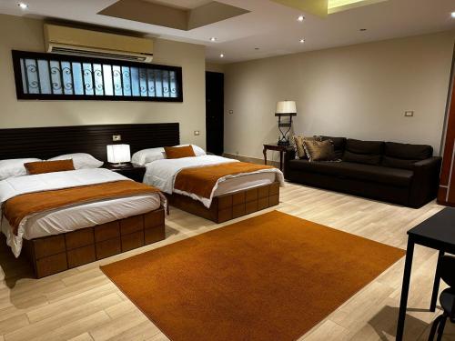 a large bedroom with two beds and a couch at Rentrific in Cairo