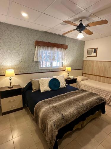 een slaapkamer met een groot bed en een plafondventilator bij Hotel Sans Souci in Belén de Escobar