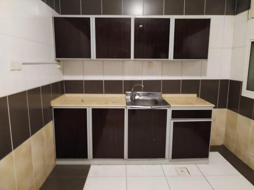 a small kitchen with a sink and black and white tiles at شقق الاحلام بحراء للايجار الشهري والسنوي in Jeddah