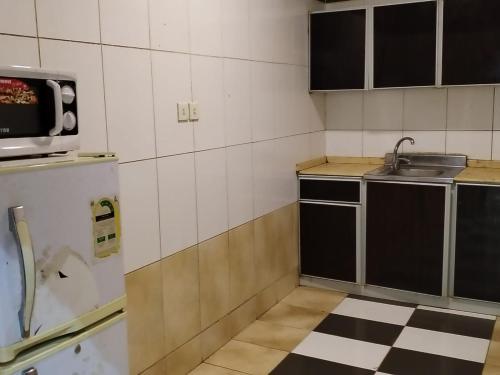 a small kitchen with a sink and a microwave at شقق الاحلام بحراء للايجار الشهري والسنوي in Jeddah