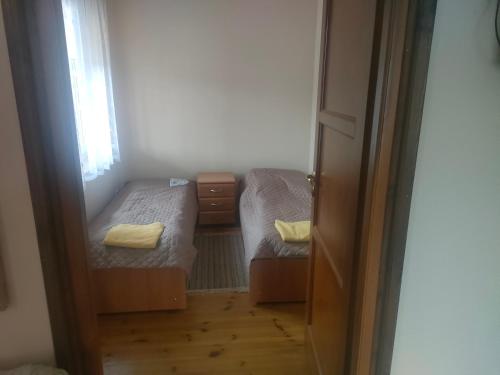 um pequeno quarto com 2 camas e uma janela em Family Kamp Domaniów 