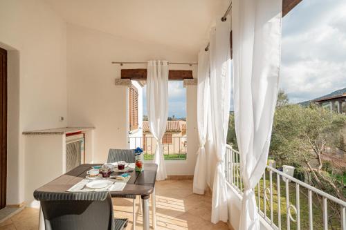 a room with a balcony with a table and chairs at Residenza L'Alzoni in San Teodoro