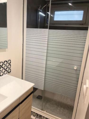 une douche avec une porte vitrée dans une salle de bain dans l'établissement T3 Orléans charmant avec parking centre-ville, à Orléans