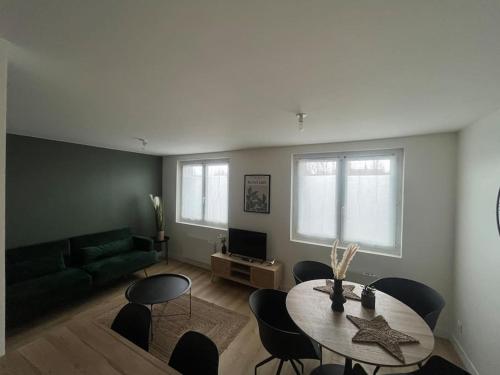 a living room with a table and a couch at T3 Orléans charmant avec parking centre-ville in Orléans