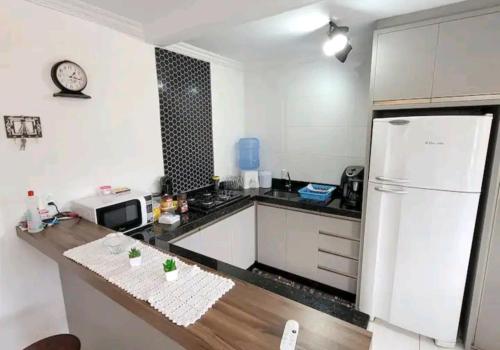 Il comprend une cuisine équipée d'un réfrigérateur blanc et d'un comptoir. dans l'établissement Apartamento novo e completo!, à Brusque