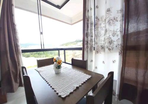 a dining room table with a vase of flowers on it at Apartamento novo e completo! in Brusque