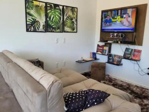 a living room with a couch and a flat screen tv at Apartamento novo e completo! in Brusque