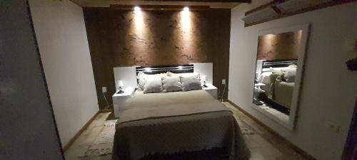 sypialnia z dużym łóżkiem i lustrem w obiekcie Angeles w mieście La Paloma