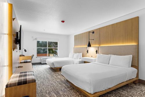 een hotelkamer met 2 bedden en een televisie bij The Evergreen Hotel in McCall