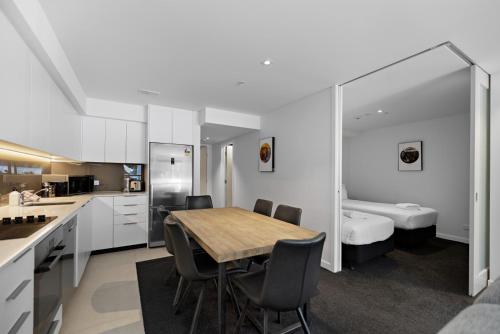 a kitchen and dining room with a table and chairs at Residence du Parc - Luxury Apartment in Paraparaumu Beach