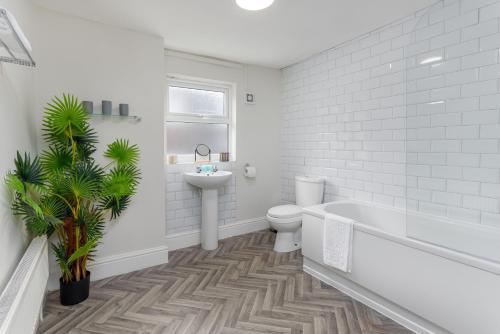 a bathroom with a tub and a toilet and a sink at Air Host & Stay - Newcombe House, 3 bedroom free parking in Liverpool