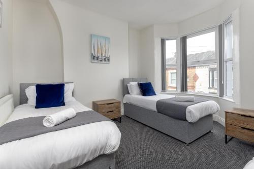 a bedroom with two beds and a window at Air Host & Stay - Newcombe House, 3 bedroom free parking in Liverpool