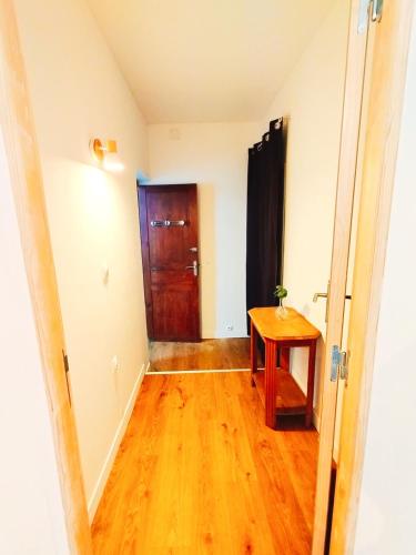 a hallway with a wooden table and a door at Beau studio indépendant in Arraute-Charritte