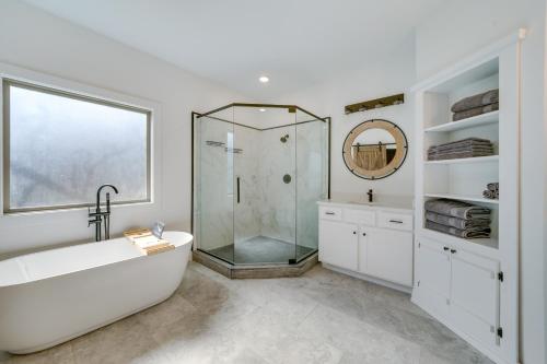 a white bathroom with a tub and a shower at Broken Bow Cabin about 5 Mi to Beavers Bend State Park in Broken Bow