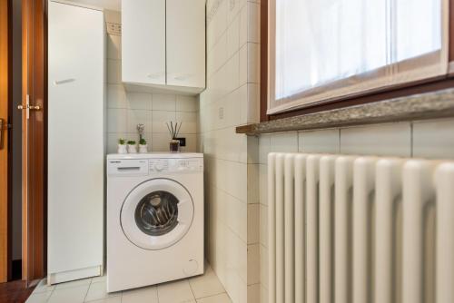 a laundry room with a washer and a radiator at Appartamento vicino a Milano, LIUC e MXP in Legnano