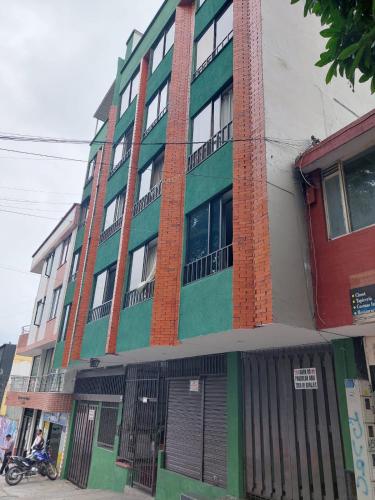 a building on a street with a motorcycle parked in front at Apartamento El Rosal in Ibagué
