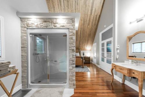 uma casa de banho com um chuveiro e uma parede de pedra em Le Fitchbay em Magog-Orford