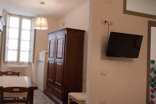a living room with a cabinet and a television on a wall at affittacamere Monte inni in Ozieri