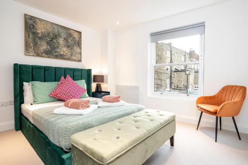 Belgravia Residence في لندن: غرفة نوم بسرير اخضر مع كرسي ونافذة