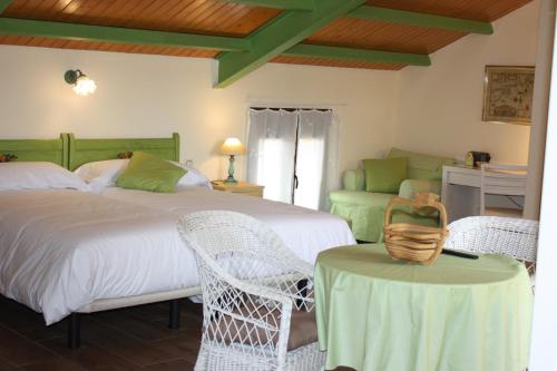 a bedroom with two beds and a table and chairs at Casa de Vivar a 5 minutos de Puy du Fou in Toledo