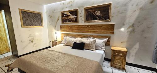ein Schlafzimmer mit einem großen Bett und zwei Bildern an der Wand in der Unterkunft Hotel Sexta Avenida in Tapachula