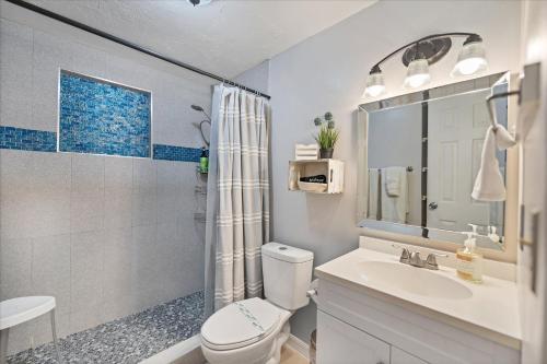 een badkamer met een toilet, een wastafel en een douche bij Beach Cottage with heated pool just off Siesta Key in Sarasota
