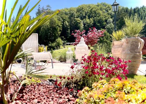 a garden with flowers and a bench and a street light at Guest Apartment & Room Seeland in Suberg
