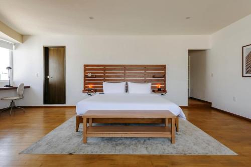 um quarto com uma cama grande e uma cabeceira em madeira em Stunning penthouse with terrace in Condesa em Cidade do México