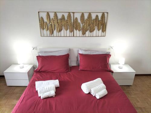 czerwone łóżko z dwoma białymi poduszkami w obiekcie Borgo 90 Bergamo house w Bergamo