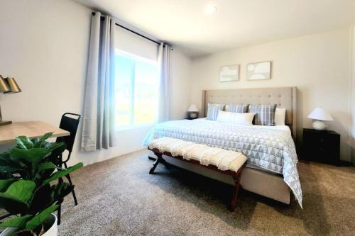 a bedroom with a bed and a table and a window at The perfect get away home in Garden City