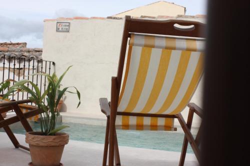 a chair sitting on a porch with a potted plant at Casa de Vivar a 5 minutos de Puy du Fou in Toledo