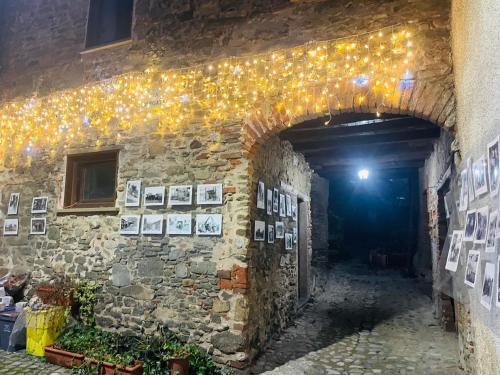 a stone tunnel with lights and pictures on the wall at Casa Borgata in Grondona