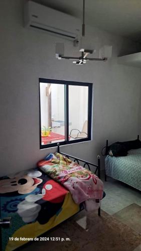 Schlafzimmer mit einem Bett und einem Fenster in der Unterkunft La casa de Mamá in Coatzacoalcos