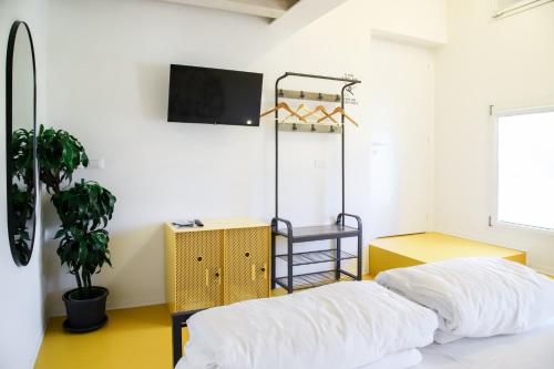 a bedroom with a bed and a tv on a wall at Nomad Hostel in Treviso