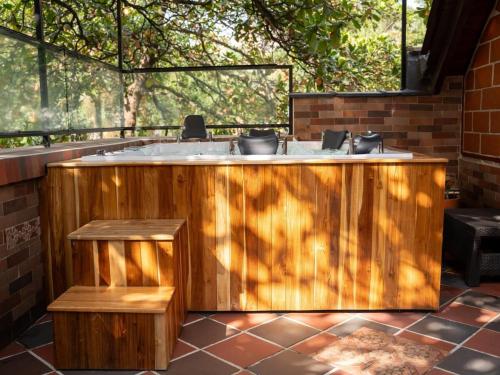 麦德林Luxury Living in Parque Lleras & Full House的房间里有一个木制浴缸，旁边还有一棵树。