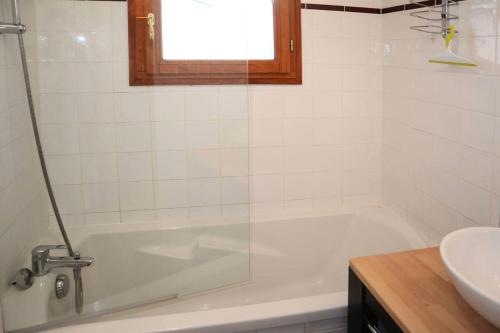 a white bathroom with a tub and a sink at Chalet La Combe D Or - Superbe chalet 10 personnes MAE-3584 in Le Mélézet
