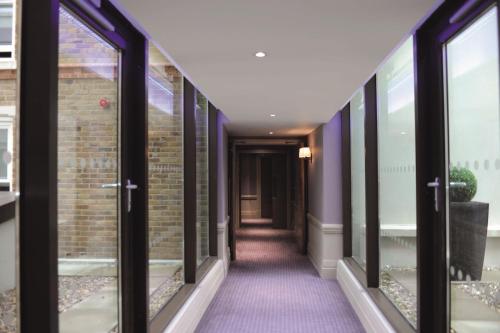 a corridor of a building with windows at Macdonald Windsor in Windsor