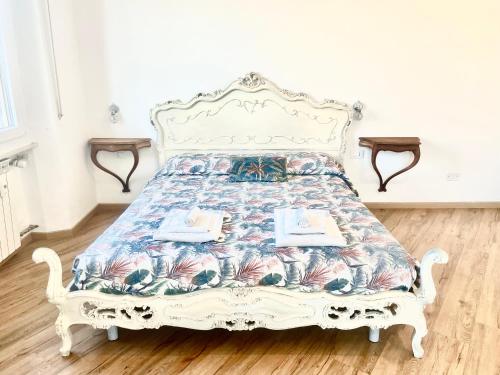 a white bed with a floral bedspread on it at Cavour16 rent bedrooms in Genova