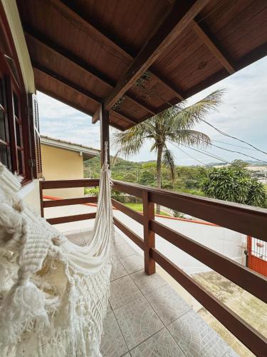 a hammock on a balcony with a view of the ocean at Morada Verde - AP 2 quartos in São José