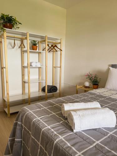 a bedroom with a bed with two towels on it at Morada Verde - Ar Cond - Garagem - Arena Opus in São José
