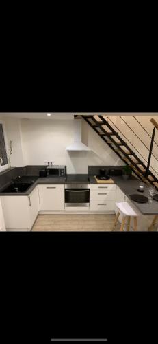 une cuisine avec un évier et une cuisinière four supérieur dans l'établissement Maison cosy au coeur du vignoble d'Hautvillers, à Hautvillers