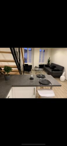ein Wohnzimmer mit einem Tisch und einem Sofa in der Unterkunft Maison cosy au coeur du vignoble d'Hautvillers in Hautvillers