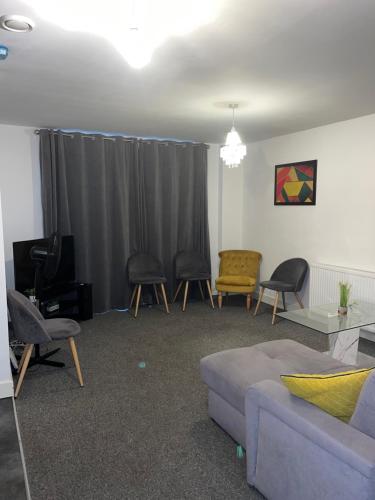 a living room with a couch and chairs at 1 Bed Apartment close to Heathrow Airport in Colnbrook