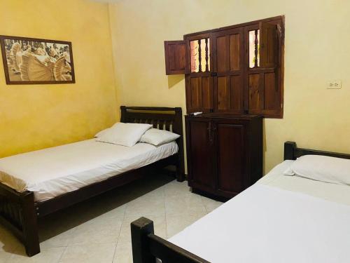 a room with two beds and a cabinet in it at CASA MORALES in Santa Fe de Antioquia