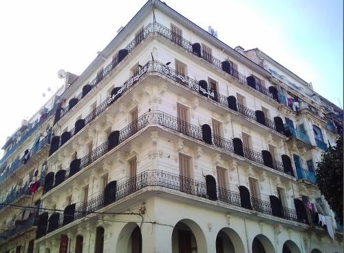 um edifício branco com varandas ao lado em Hotel Nelson - Bab El Oued em Bab el Oued