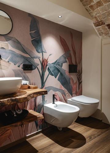 a bathroom with two sinks and a toilet at MATTEI LUXURY B&B in Altamura