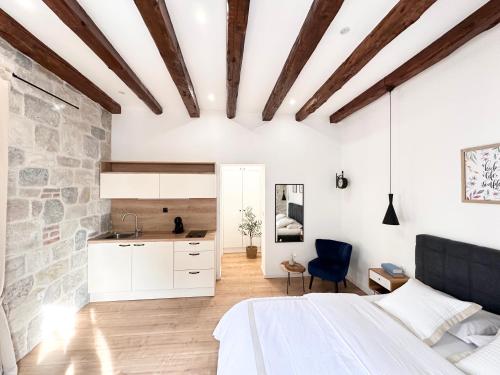 - une chambre avec un lit blanc et un mur en pierre dans l'établissement Agora, à Split